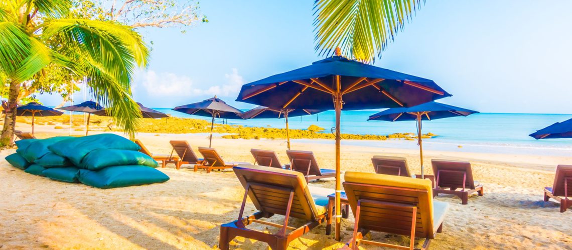 Umbrella and chair on the beautiful tropical beach and sea landscape with coconut palm tree - Boost up color Processing